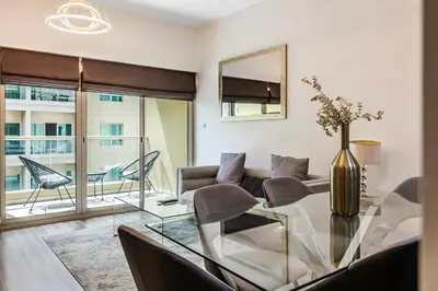 a living room with a glass table and a couch at 1BR The Greens Courtyard View in Dubai