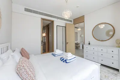 a white bedroom with a large white bed and a mirror at Luxury at JBR Jumeirah Gate Tower 1 1 Bed in Dubai