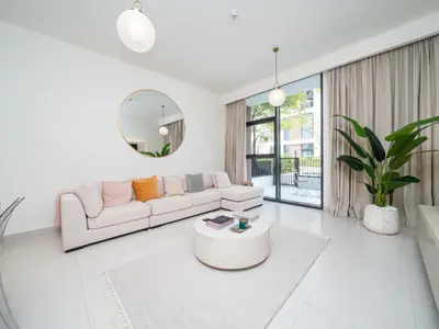 a white living room with a couch and a mirror at Dubai Hills Elegant 1-Bed with Terrace in Dubai