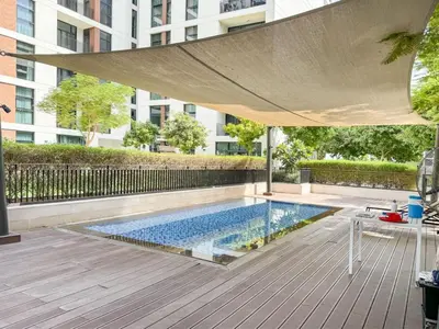 an umbrella over a swimming pool in a building at Dubai Hills Elegant 1-Bed with Terrace in Dubai