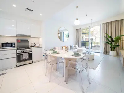 a kitchen and living room with a table and chairs at Dubai Hills Elegant 1-Bed with Terrace in Dubai