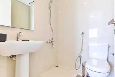 a bathroom with a sink and a toilet and a mirror at 2 BR with Maid's Next to Dubai Mall Mada Residences in Dubai