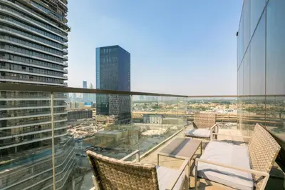 a balcony with chairs and a view of a city at 2 BR with Maid's Next to Dubai Mall Mada Residences in Dubai