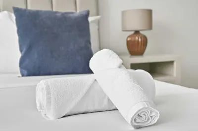 a pair of white towels on a bed at Prime Downtown Burj Khalifa I Sleeps 8 in Dubai