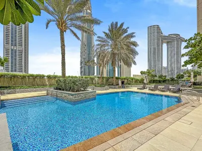 a swimming pool with palm trees and buildings at Prime Downtown Burj Khalifa I Sleeps 8 in Dubai