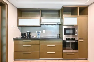a kitchen with stainless steel appliances and brown cabinets at Prime Downtown Burj Khalifa I Sleeps 8 in Dubai