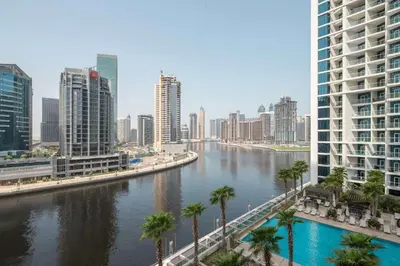 a river in a city with palm trees and buildings at Frank Porter - Damac Maison Prive B in Dubai