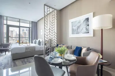 a living room with a bed and a table and chairs at Frank Porter - Damac Maison Prive B in Dubai