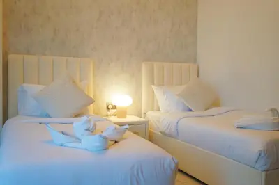 a bedroom with two beds with white flowers on them at Millennium Binghatti Residence 2BR Burj Khalifa and Lake in Dubai