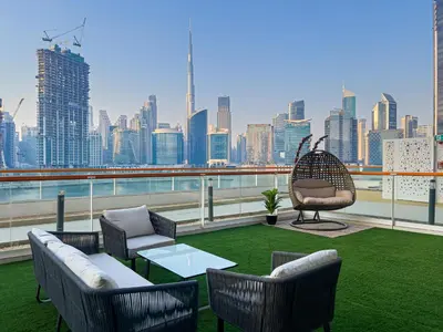 a rooftop patio with a view of a city skyline at Millennium Binghatti Residence 2BR Burj Khalifa and Lake in Dubai