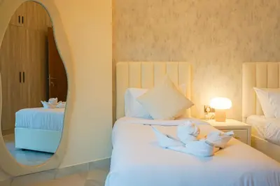 a bedroom with two beds and a mirror at Millennium Binghatti Residence 2BR Burj Khalifa and Lake in Dubai