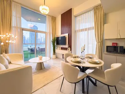 a kitchen and living room with a table and chairs at Millennium Binghatti Residence 2BR Burj Khalifa and Lake in Dubai