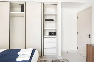 a bedroom with white closets and a bed at Silkhaus Mid Floor Marina Vista with Private Beach in Dubai