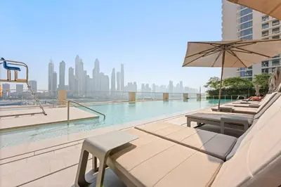 a pool with chairs and an umbrella on a building at Silkhaus Mid Floor Marina Vista with Private Beach in Dubai
