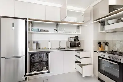 a white kitchen with white cabinets and appliances at Silkhaus Mid Floor Marina Vista with Private Beach in Dubai