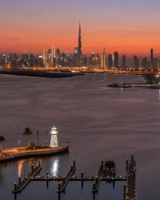 a view of a city with a lighthouse in the water at Contemporary 1BR condo with pool at Creek Harbour in Dubai