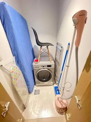 a small room with a washing machine and a chair at Contemporary 1BR condo with pool at Creek Harbour in Dubai
