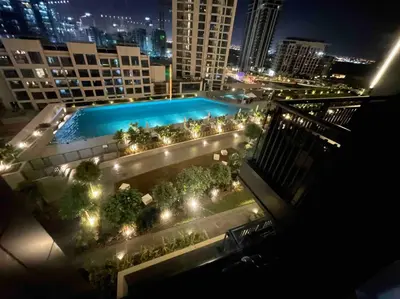 a view of a pool on top of a building at night at Contemporary 1BR condo with pool at Creek Harbour in Dubai