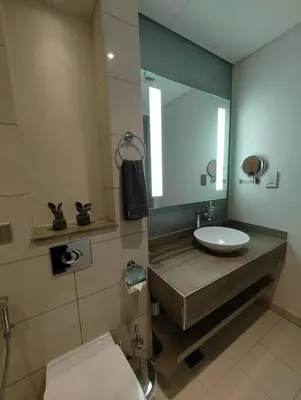 a bathroom with a sink and a mirror and a toilet at 2BR Tower D Paramount Apartment in Dubai