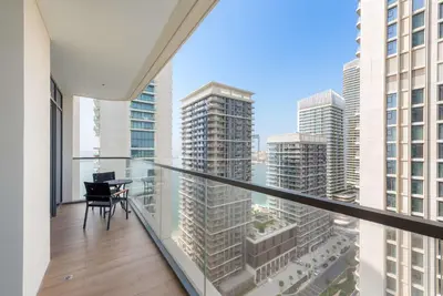 a balcony with a table and a view of a city at Silkhaus 1BDR with Private Beach Marina Vista in Dubai