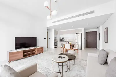 a living room with a couch and a tv at Silkhaus 1BDR with Private Beach Marina Vista in Dubai