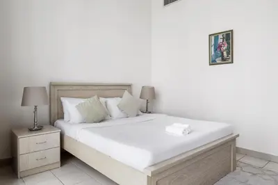 a bedroom with a large bed with white sheets and pillows at 2BR Torch Tower High Floor Dubai Marina in Dubai