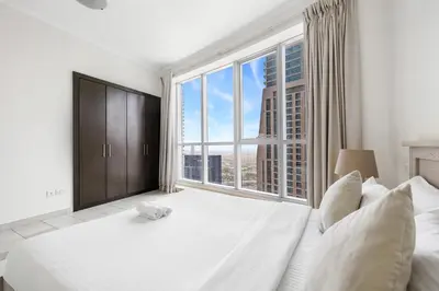 a bedroom with a large bed with a large window at 2BR Torch Tower High Floor Dubai Marina in Dubai