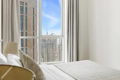 a bedroom with a large window with a view of a city at 2BR Torch Tower High Floor Dubai Marina in Dubai