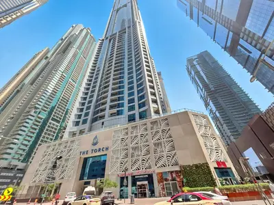 a building in a city with two tall buildings at 2BR Torch Tower High Floor Dubai Marina in Dubai