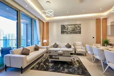 a living room with a couch and chairs and a table at 3BR Burj Khalifa Fountain Views Forte 1- 18th floor in Dubai