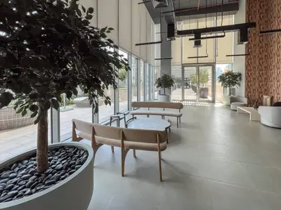 a lobby with benches and a tree in a building at 3BR Burj Khalifa Fountain Views Forte 1- 18th floor in Dubai