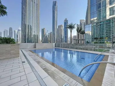 a swimming pool in a city with tall buildings at 3BR Burj Khalifa Fountain Views Forte 1- 18th floor in Dubai