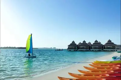 a row of boats on a beach in the water at AWS Holiday Homes - Oasis in the Palm in Dubai