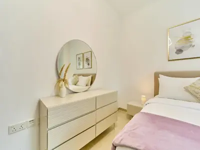 a bedroom with a bed and a mirror on a dresser at Golden homes Residences Tower 05 1BR CITY VIEW Near Dubai mall & burj khalifa in Dubai