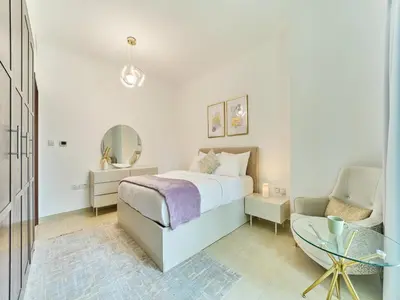 a white bedroom with a bed and a chair at Golden homes Residences Tower 05 1BR CITY VIEW Near Dubai mall & burj khalifa in Dubai