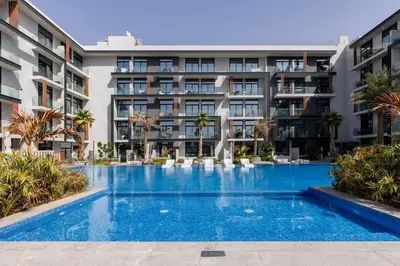 an empty swimming pool in front of a building at Waves - Tranquil Living 2BR Apt in JVC with City Views in Dubai