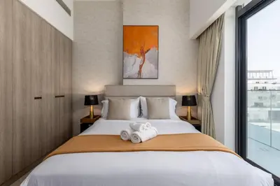 a bedroom with a large bed with towels on it at Waves - Tranquil Living 2BR Apt in JVC with City Views in Dubai