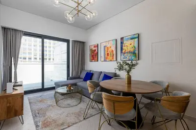 a living room with a table and a couch at Waves - Tranquil Living 2BR Apt in JVC with City Views in Dubai