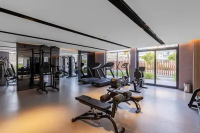 a gym with several treadmills and machines in a room at Waves - Tranquil Living 2BR Apt in JVC with City Views in Dubai