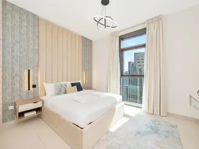 a white bedroom with a large bed and a window at 2BR Burj Khalifa & Fountain Views Burj Crown 39th Floor in Dubai