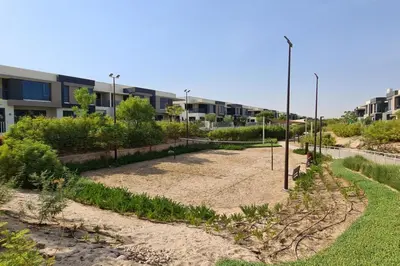 an empty garden in front of an apartment building at NewArabian Dubai HillsMaple Villa in Dubai