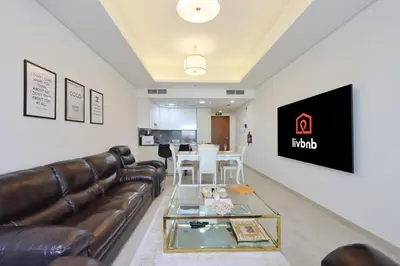 a living room with a leather couch and a table at Livbnb-Tranquil 1B Steps to PalmBoardwalk Sea View in Dubai