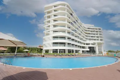 a large building with a swimming pool in front of it at Livbnb-Tranquil 1B Steps to PalmBoardwalk Sea View in Dubai