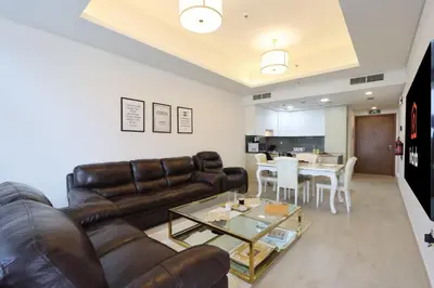a living room with a leather couch and a table at Livbnb-Tranquil 1B Steps to PalmBoardwalk Sea View in Dubai