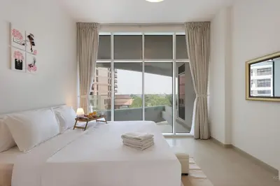 a bedroom with a large white bed and a large window at Livbnb-Tranquil 1B Steps to PalmBoardwalk Sea View in Dubai
