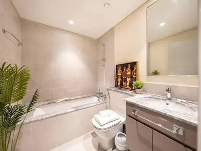 a bathroom with a tub and a toilet and a sink at Panoramic Full Fountain,Opera& burj Sky View 4BR APT in Dubai