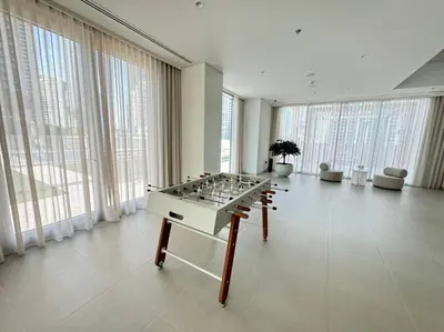 a large room with a foosball table in front of windows at Panoramic Full Fountain,Opera& burj Sky View 4BR APT in Dubai