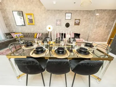 a dining room with a glass table and chairs at Panoramic Full Fountain,Opera& burj Sky View 4BR APT in Dubai