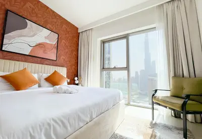 a bedroom with a bed and a chair and a window at Stunning 2 Bedroom Apartment Downtown Views 2 - Tower 3 Downtown Dubai in Dubai