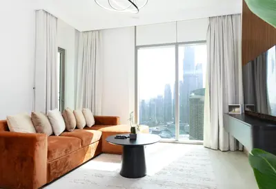 a living room with a couch and a large window at Stunning 2 Bedroom Apartment Downtown Views 2 - Tower 3 Downtown Dubai in Dubai